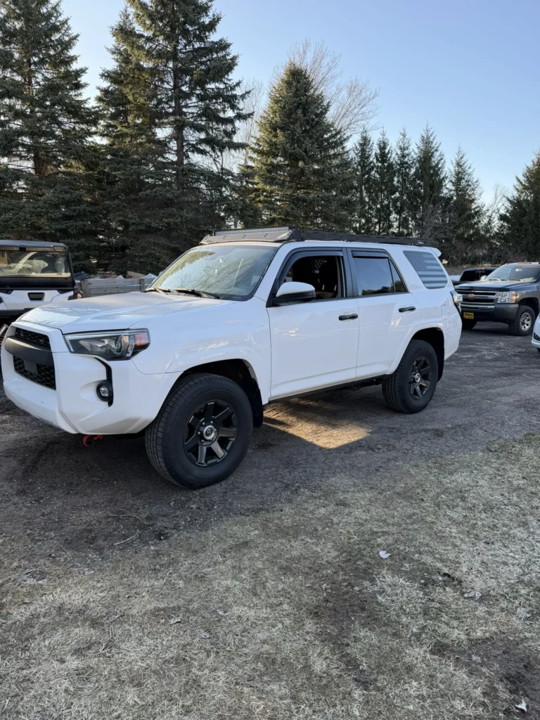 White Toyota 4Runner on new wheels and tires after a lift install